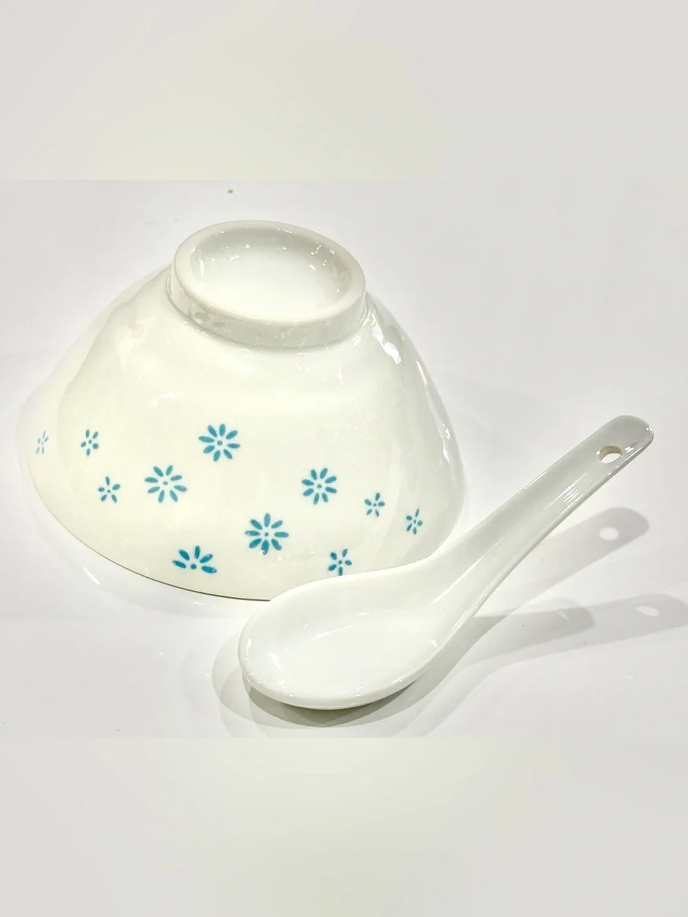 White Ceramic Bowl with Blue Floral Motif on Exterior and Matching Spoon